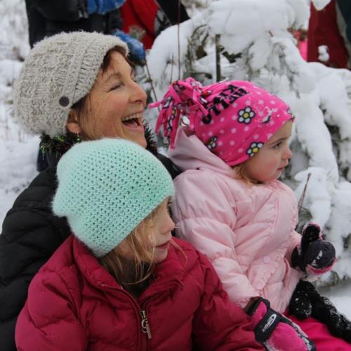 Likely a snowball fight is under way, the girls sitting with Grandmama!