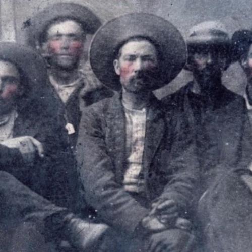 The image depicts the outlaw Billy the Kid, posing alongside the sheriff who later killed him.